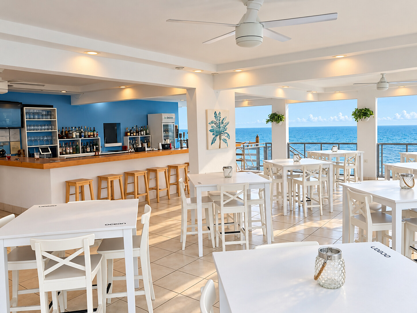 Ocean en Joyudas: barra de madera, mobiliario blanco y un salón abierto hacia el mar.