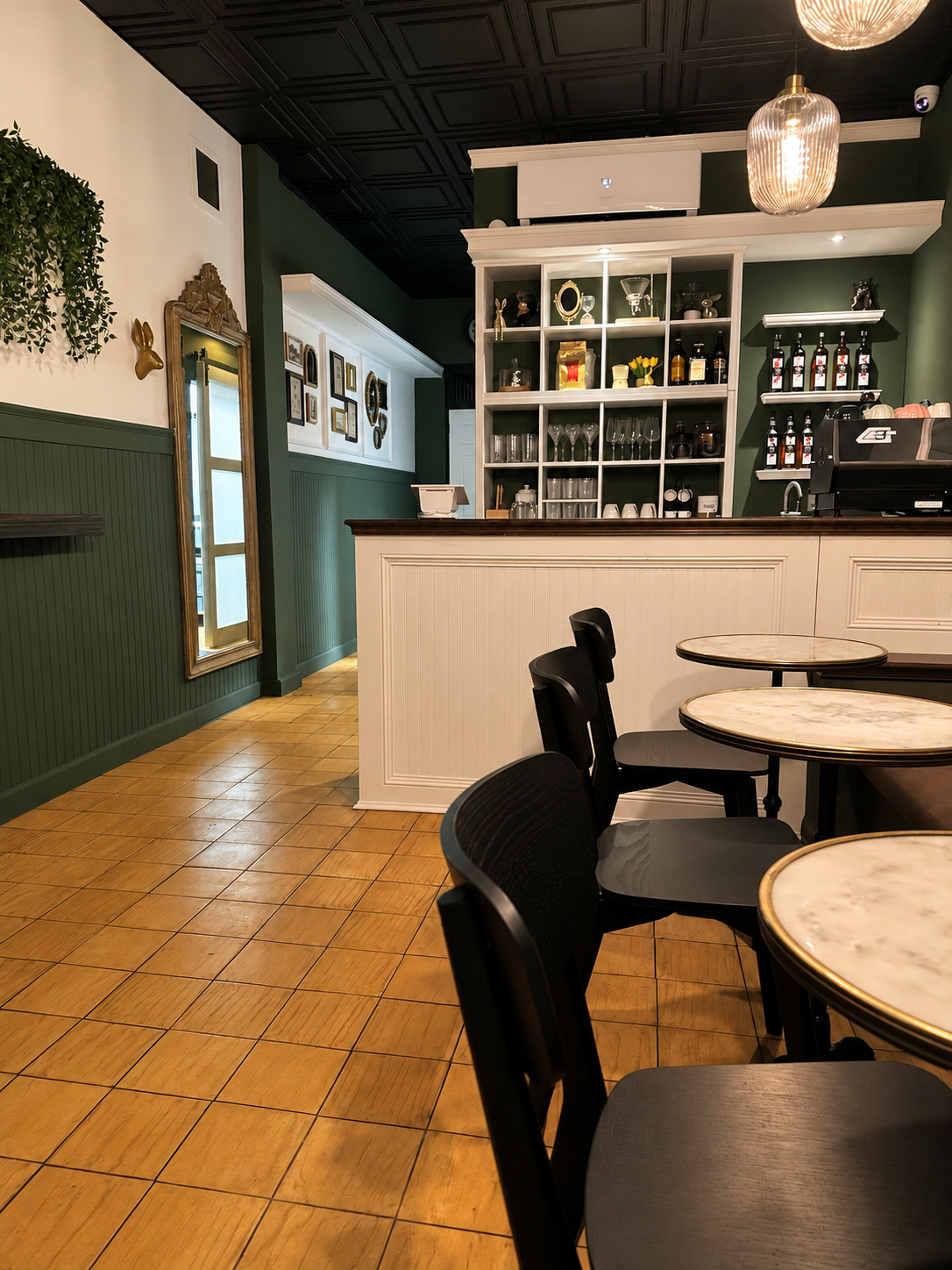 Interior de White Rabbit Betances, con paredes verdes, barra blanca y mesas de mármol.